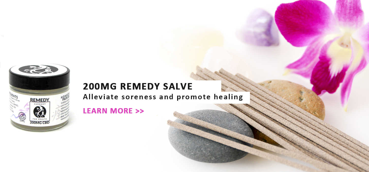 Harmony for Health Remedy Salve 200mg CBD Jar next to two rocks some incense sticks and flowers